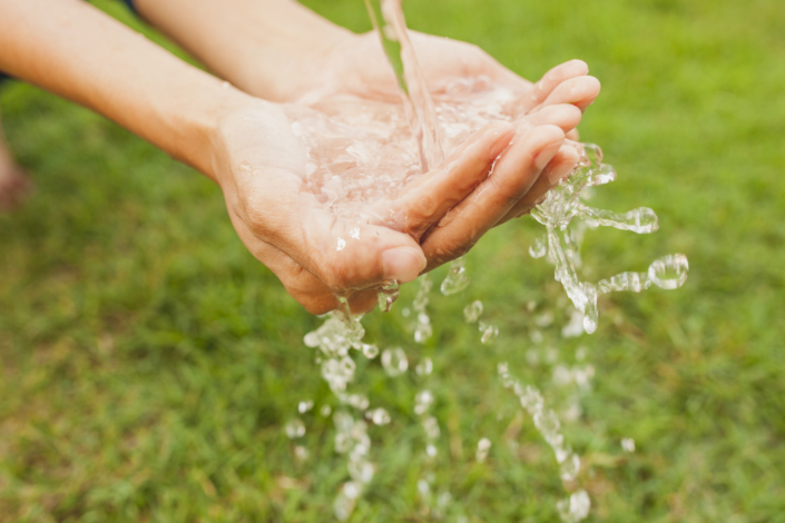 gros-plan-mains-sous-jet-eau